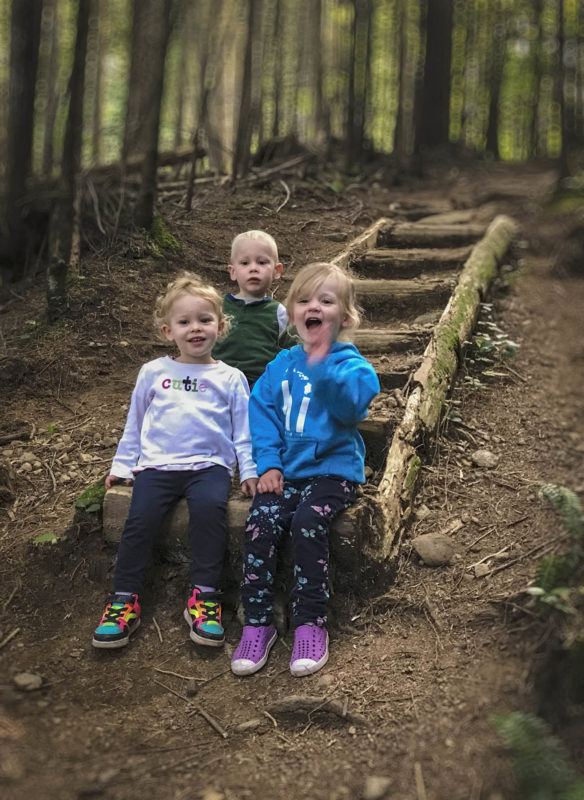 Addison, Colin and Evelyn sitting at the bottom of the stairs.