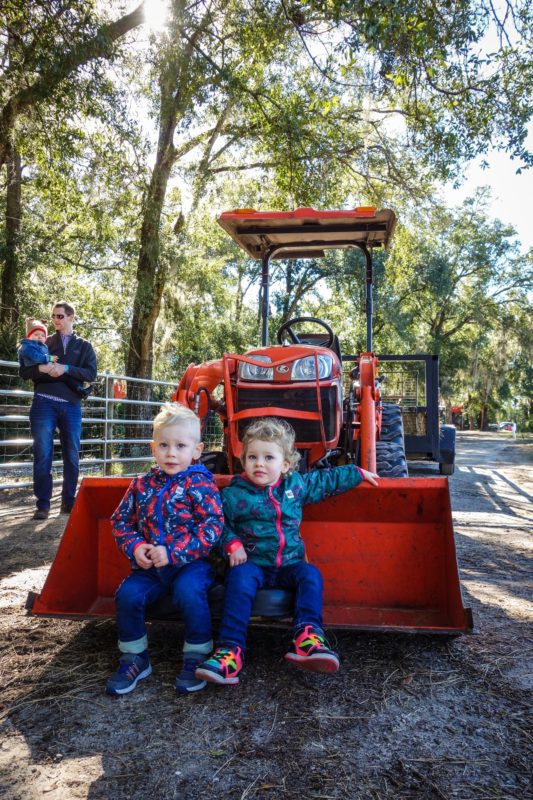 The kids pull up a seat on the front of the tractor before the hayride started.